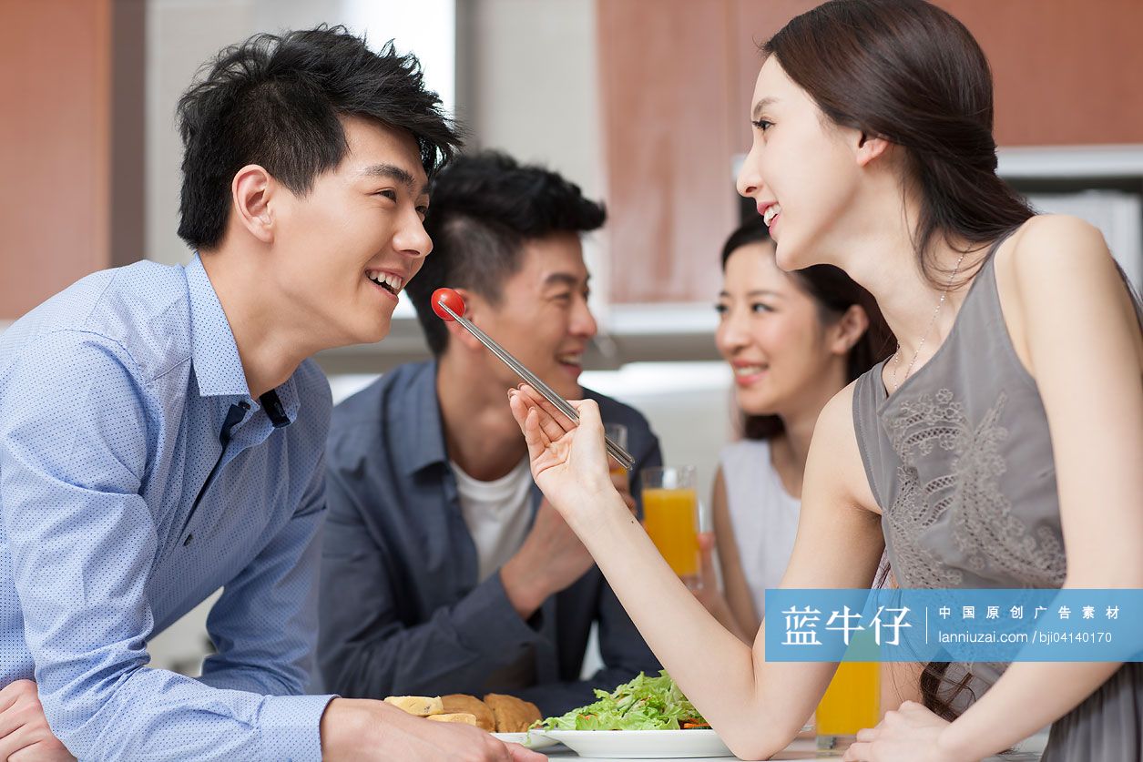 年轻女子喂男友吃菜