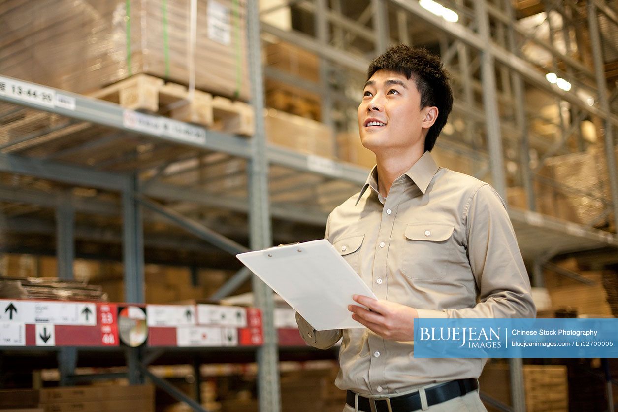 Male Chinese Warehouse Worker With Clipboard High Res Stock Photo For