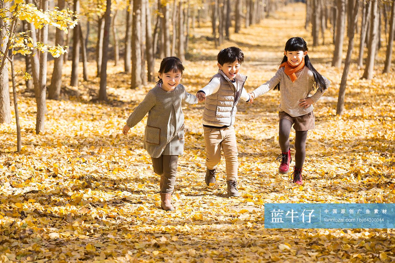 三个小孩在秋日的树林里嬉戏
