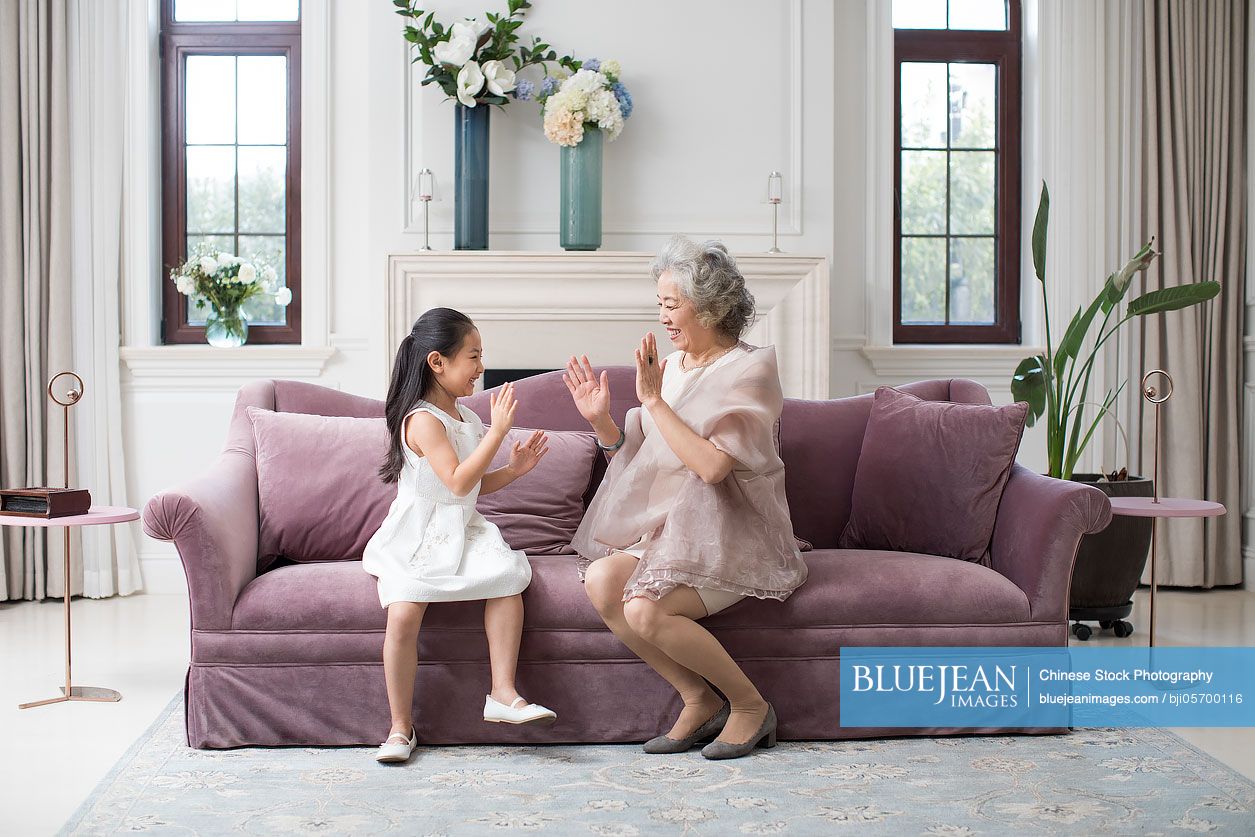 Happy Chinese Grandmother And Granddaughter Playing Clapping Game High