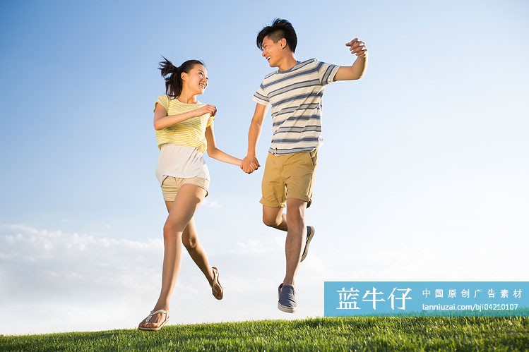 在草地上跑步的年轻情侣
