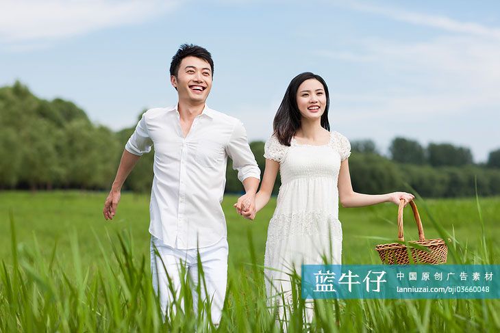 草地上的年轻情侣野餐