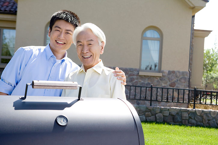 Chinese father and son chatting in front of house-High-res stock photo for download