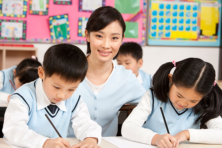 老师在课堂辅导小学生