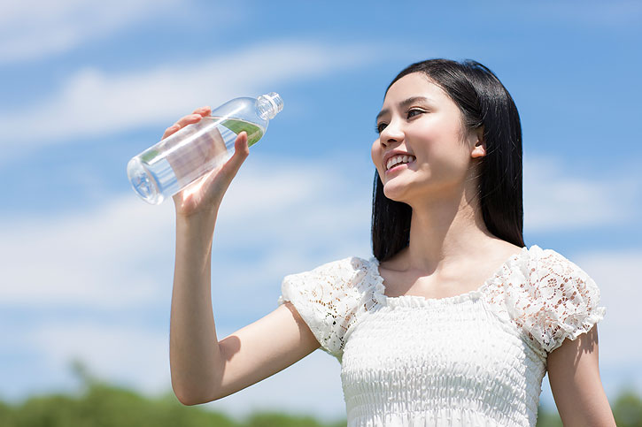 快乐的年轻女子拿着矿泉水