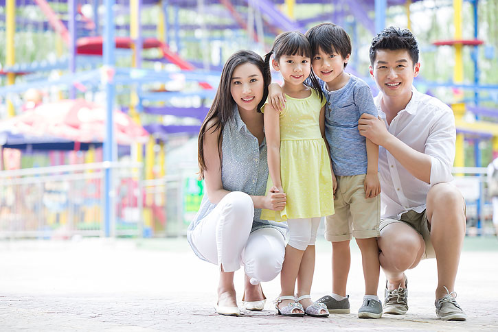 快乐的年轻家庭在游乐园嬉戏