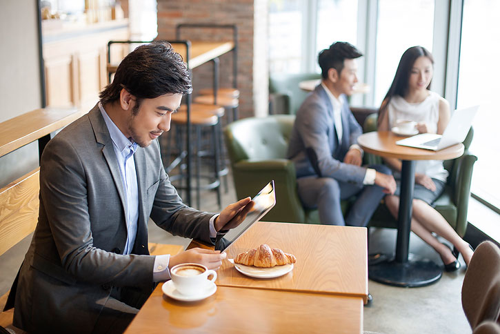 商务男士在咖啡厅使用平板电脑