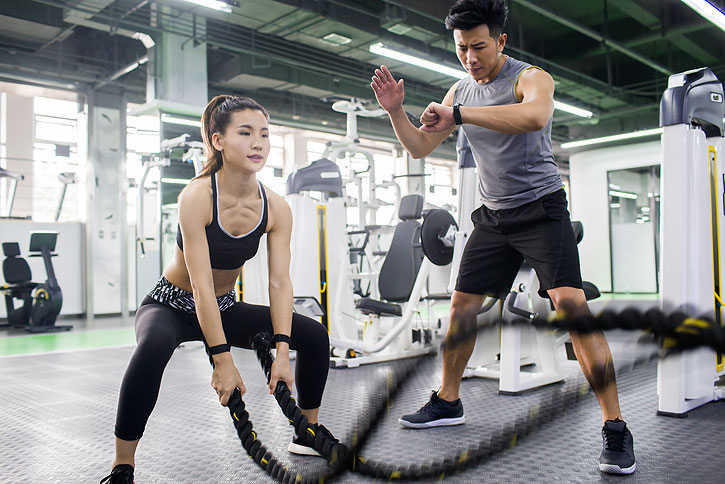 年轻女子在教练的指导下健身