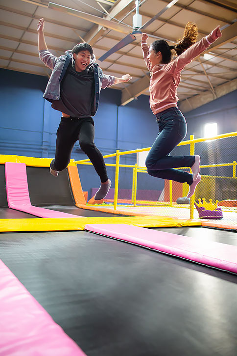 快乐的年轻情侣玩蹦蹦床