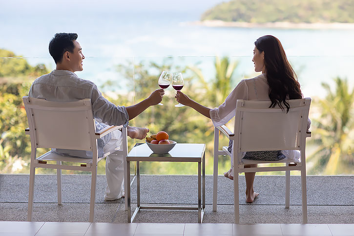 年轻夫妇在露台喝红酒