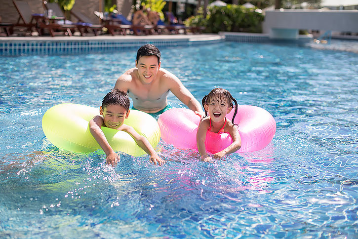 快乐的年轻家庭在泳池里玩耍