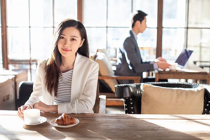 年轻商务女士在咖啡店喝咖啡