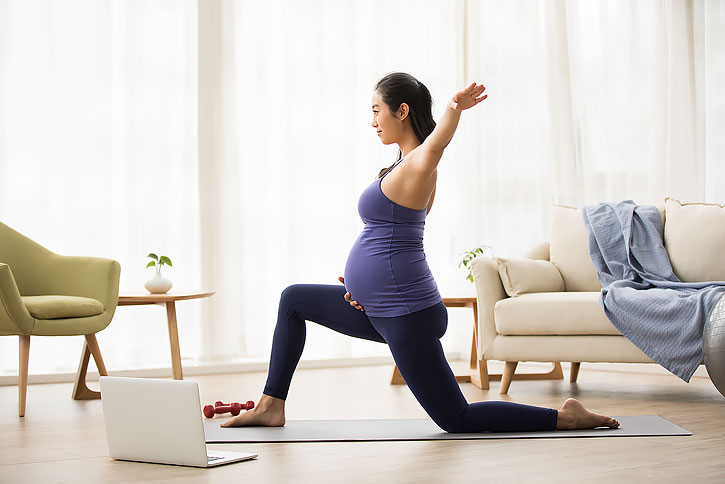 年轻孕妇在家练习瑜伽