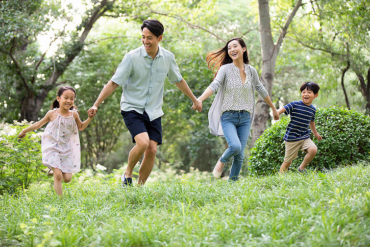 快乐年轻家庭在草地上玩耍