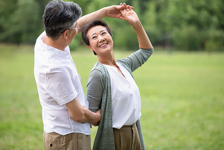 快乐老年夫妇在草地上跳舞