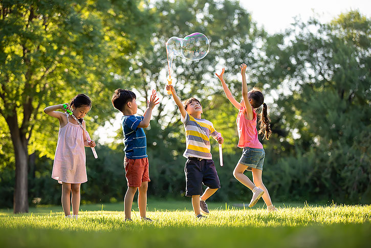 快乐的儿童在草地上吹泡泡