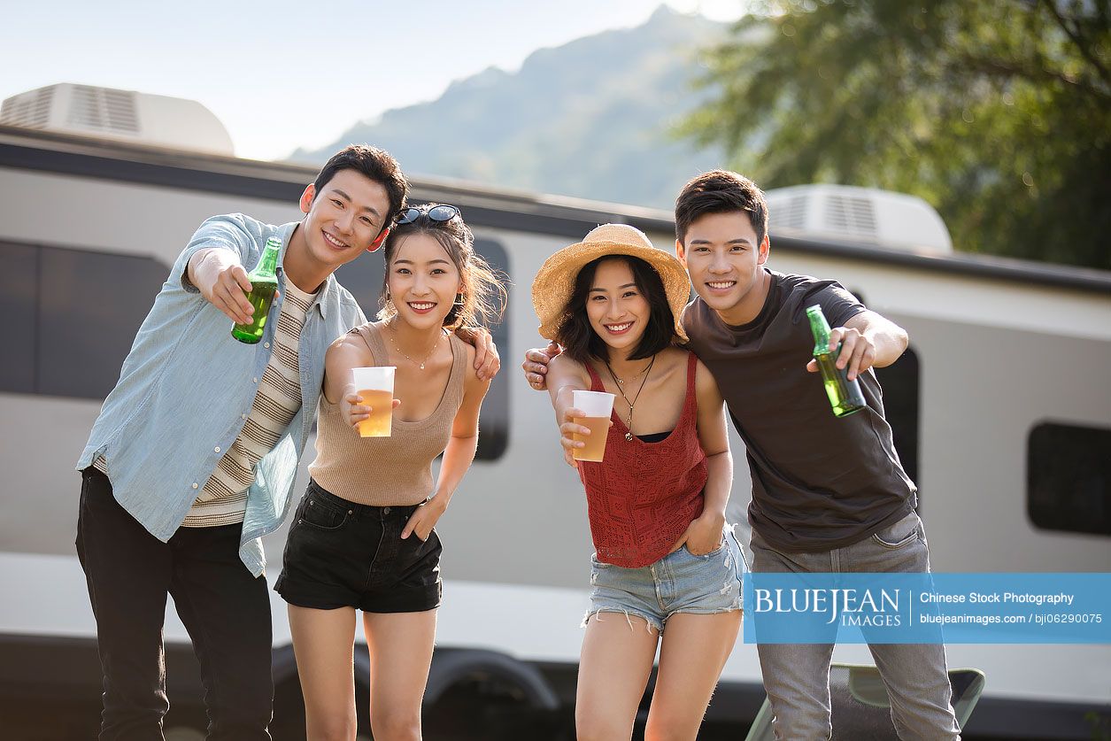 Happy young Chinese friends having a picnic outdoors