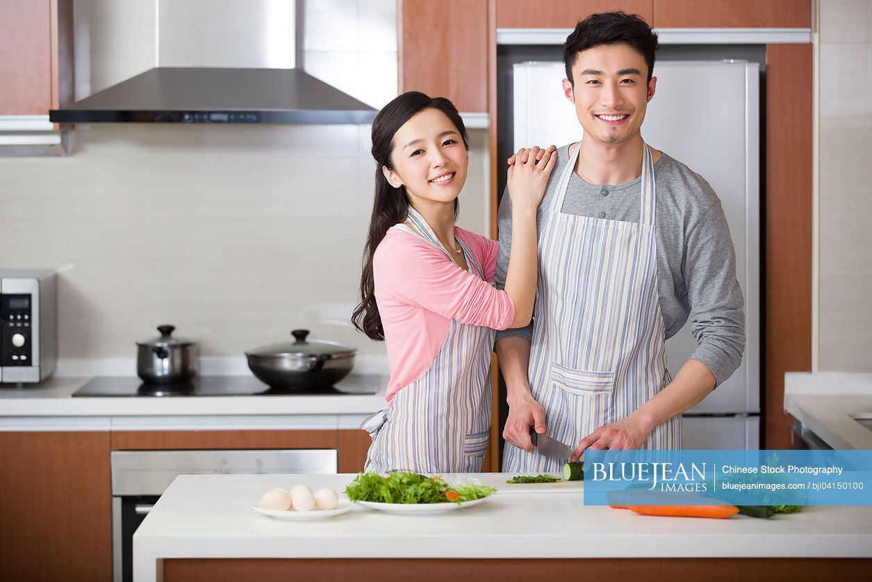 Happy young Chinese couple preparing meal