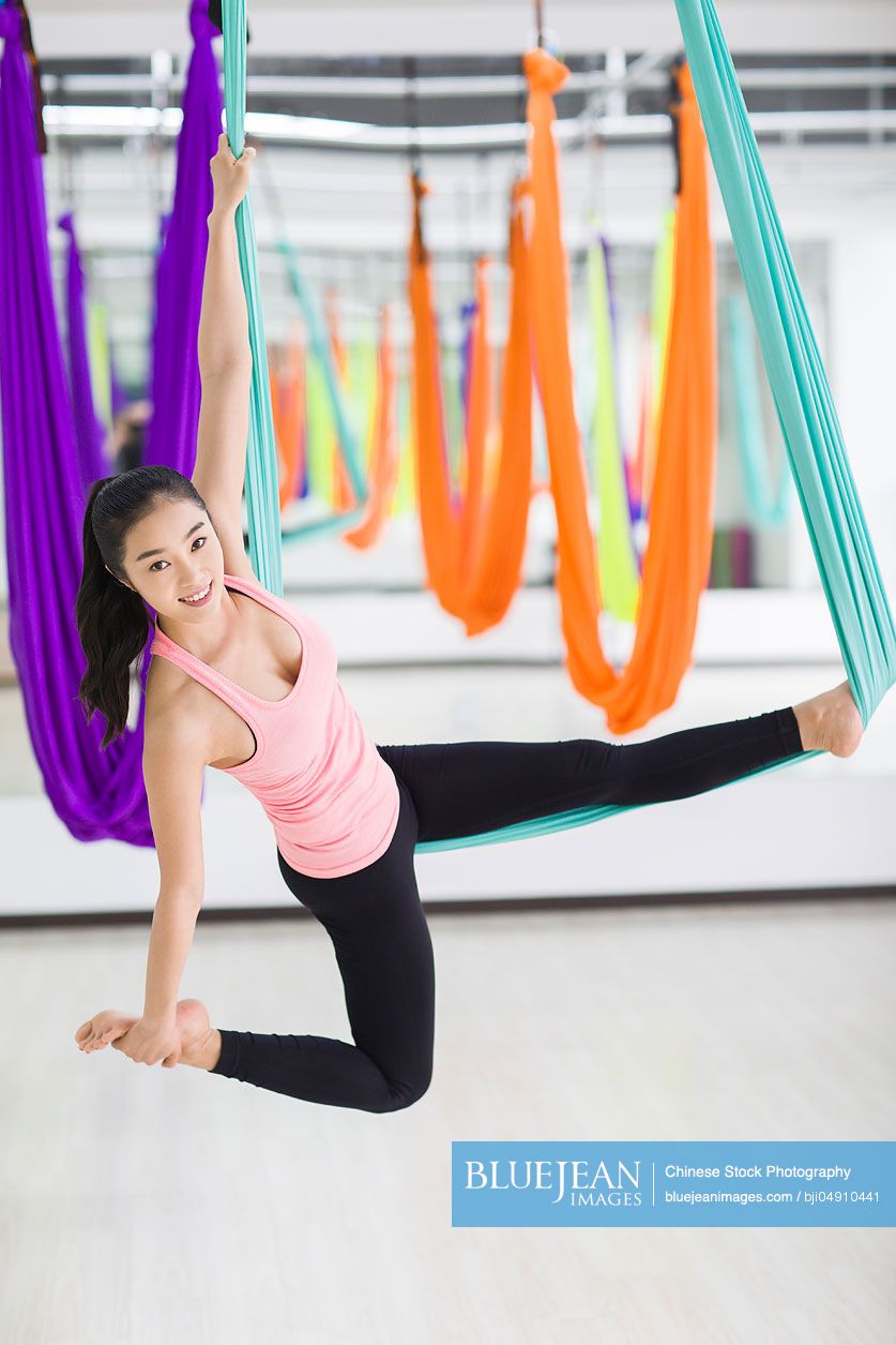 Young Chinese woman practicing aerial yoga