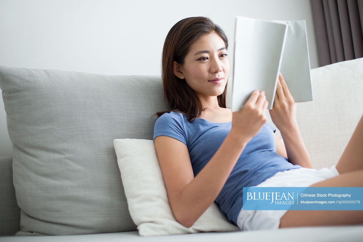 Young Chinese woman reading at home