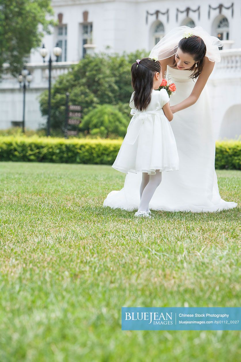 Young Chinese flower girl with the bride after a wedding