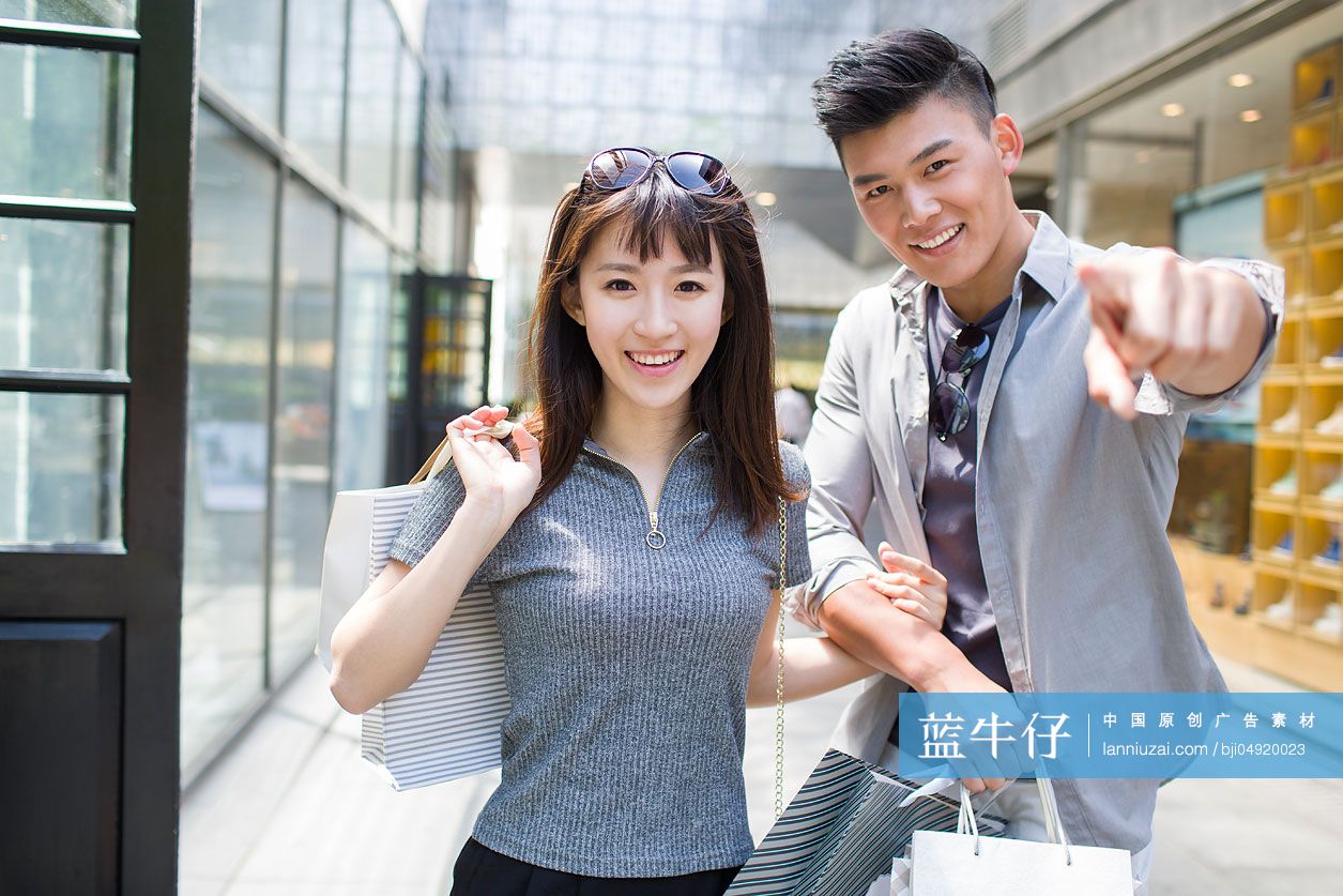 快乐的年轻情侣逛街购物