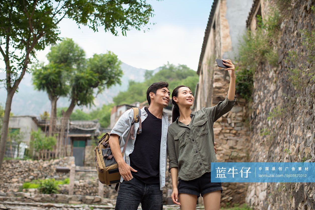 年轻情侣户外使用手机自拍