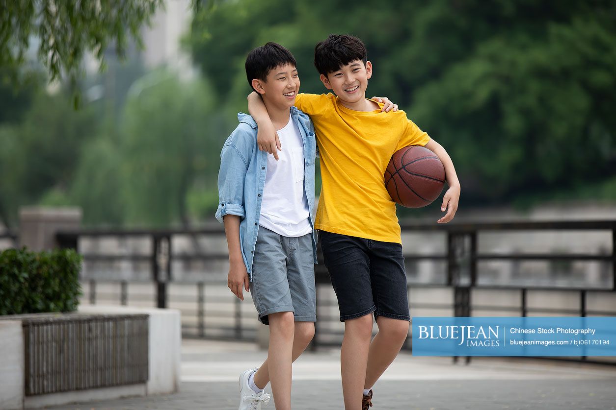 Chinese boys playing basketball outdoors