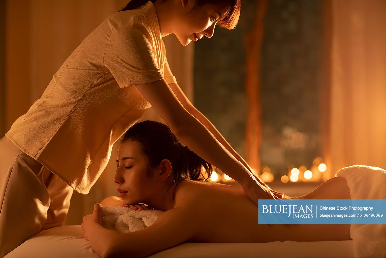 Young woman receiving a back massage in a spa center stock photo