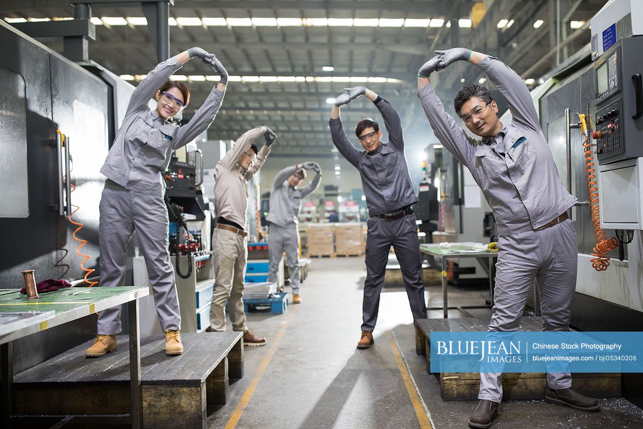 Chinese engineers stretching in the factory