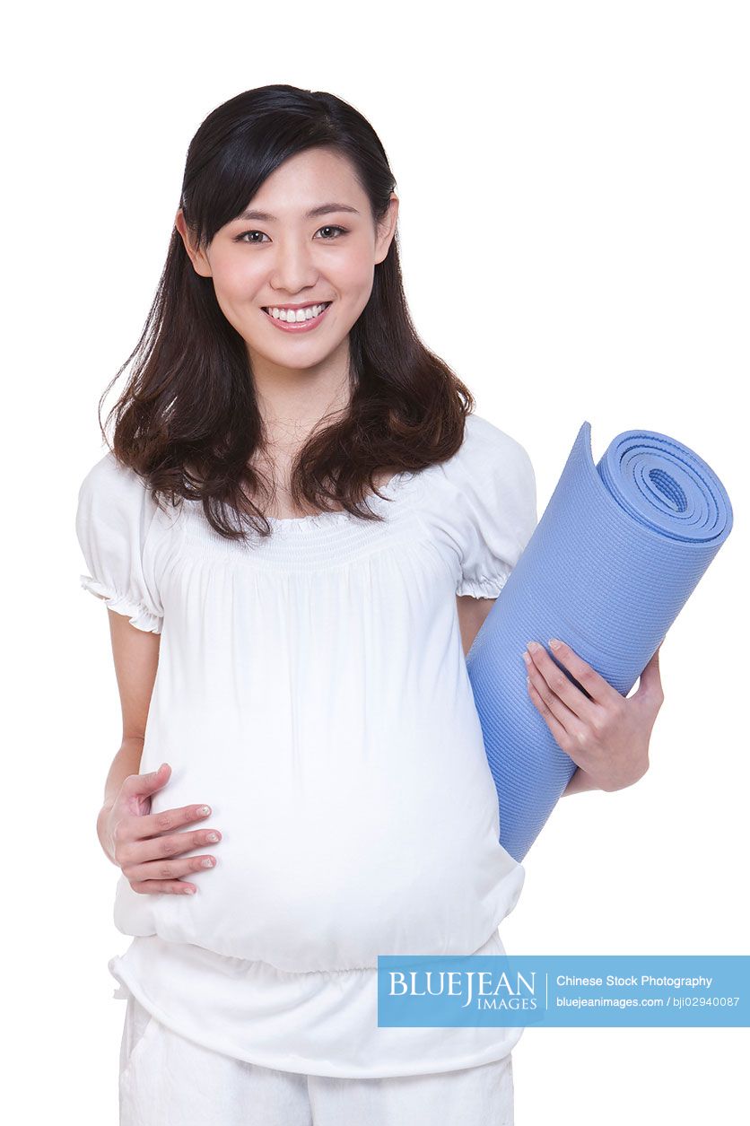 Pregnant Chinese woman with yoga mat