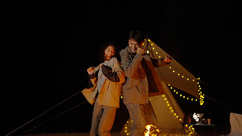 Happy young Chinese couple camping outdoors