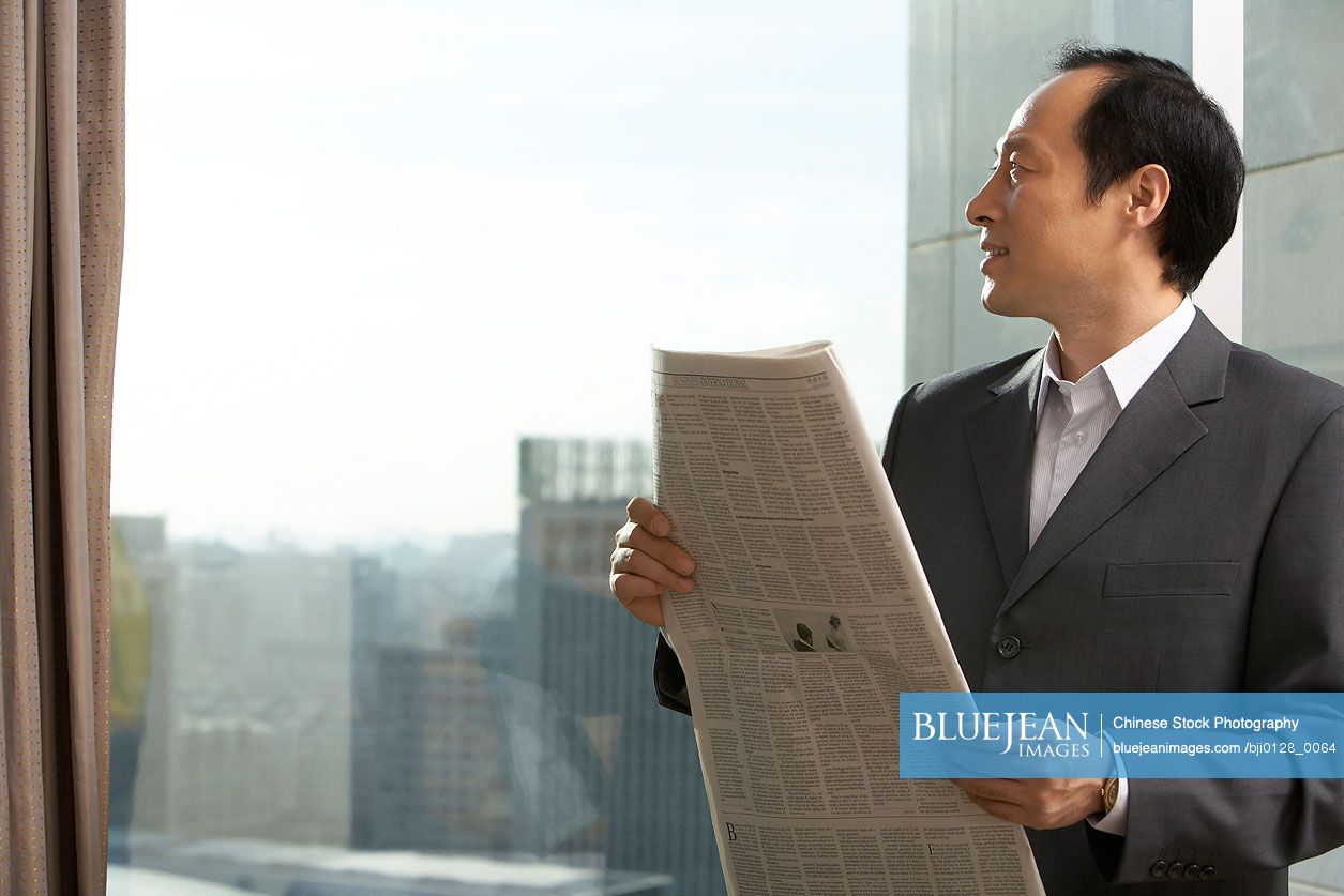 Chinese businessman with newspaper