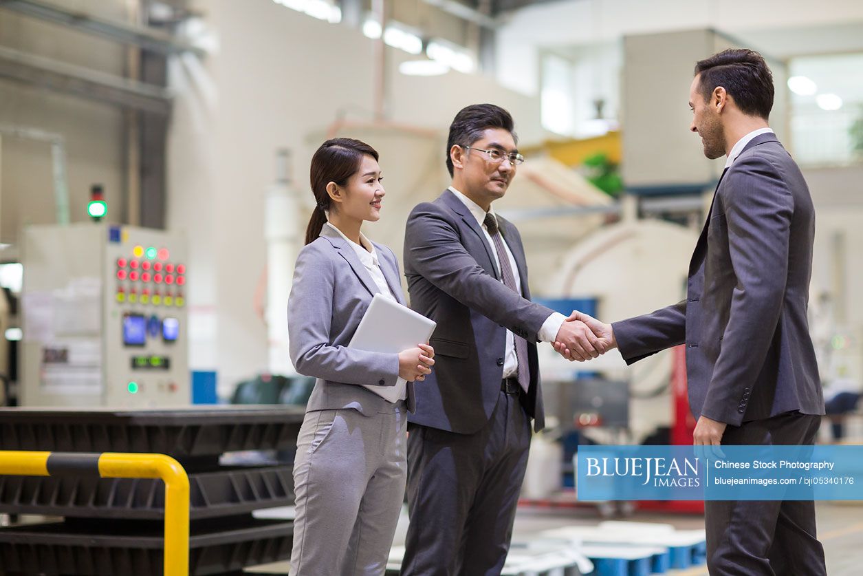 Business people shaking hands in the factory