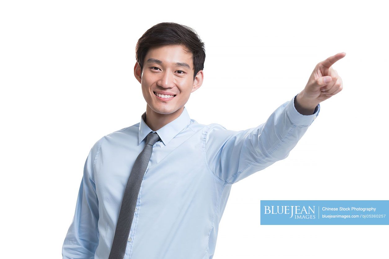 Confident young Chinese businessman pointing