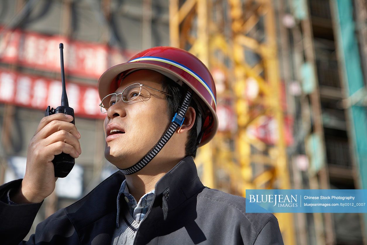 Chinese businessman in construction site wearing hard hat
