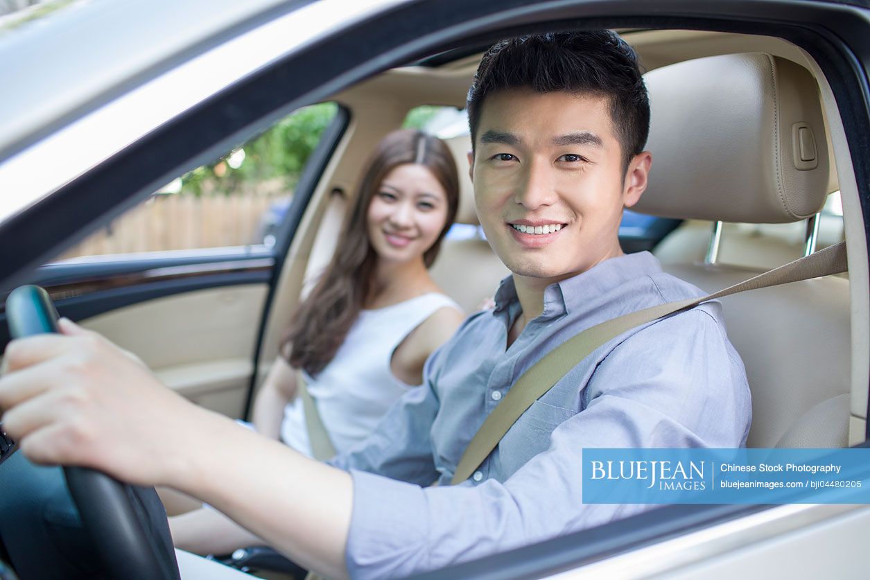 Happy young Chinese couple in a car