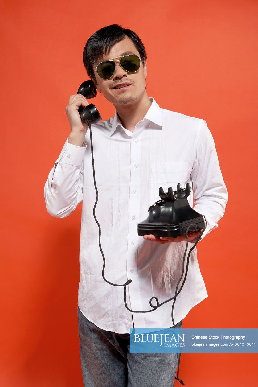 Young Chinese man talking on telephone