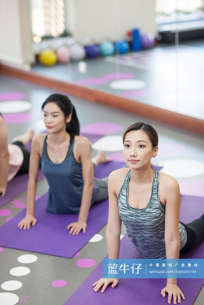 年轻闺蜜在健身房练瑜伽