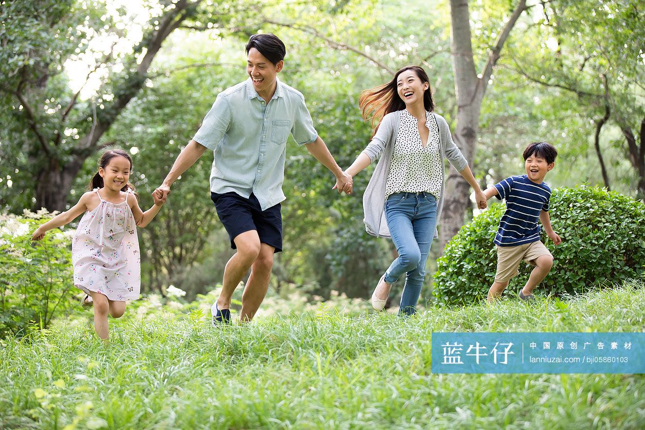 快乐年轻家庭在草地上玩耍