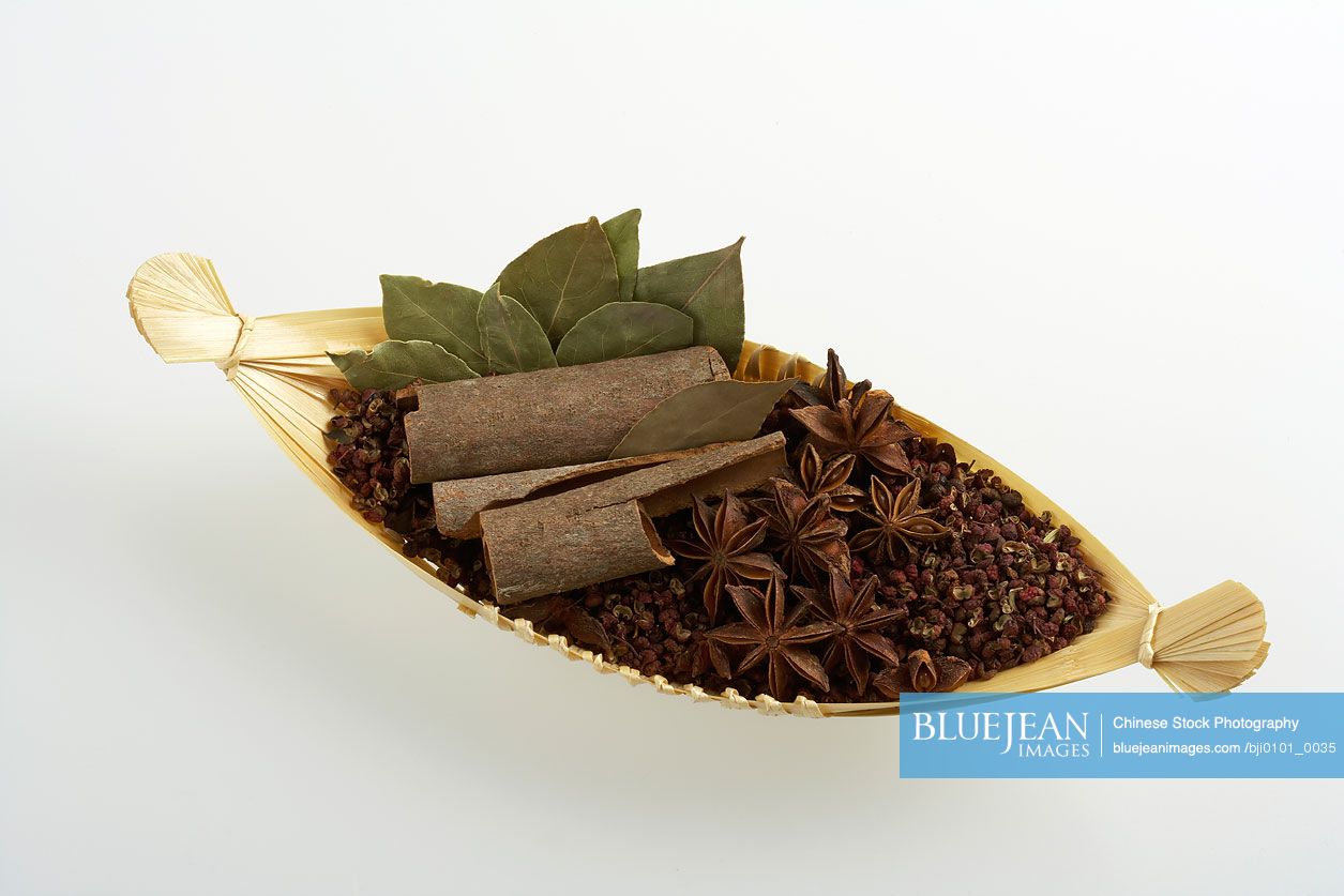 Star anise, cinnamon, spices and bay leaves in a woven basket
