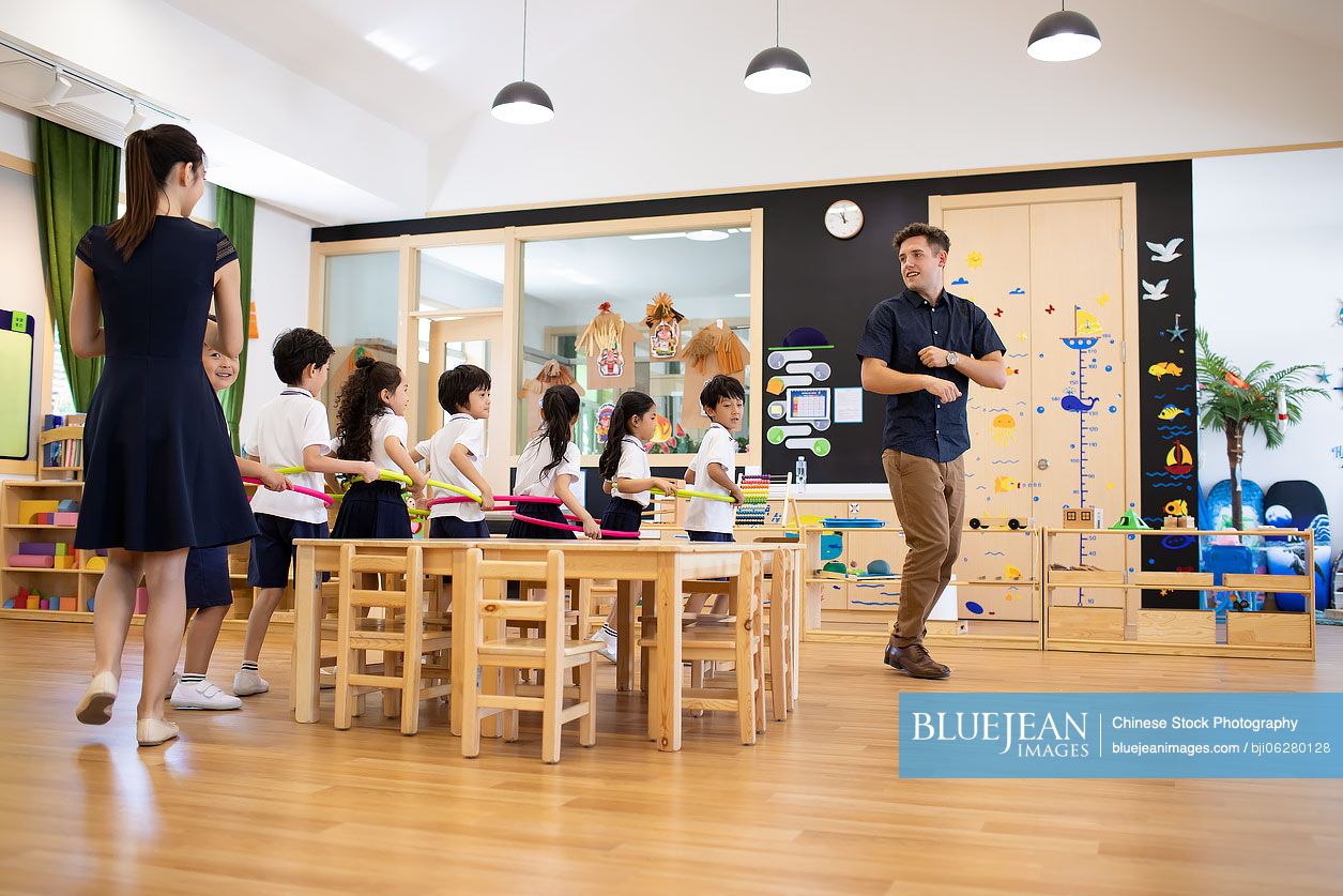 Teachers and children playing games in classroom
