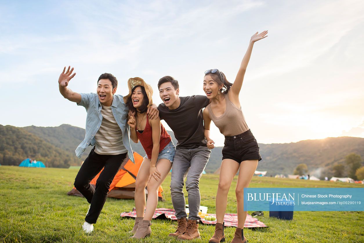 Happy young Chinese friends having a picnic outdoors