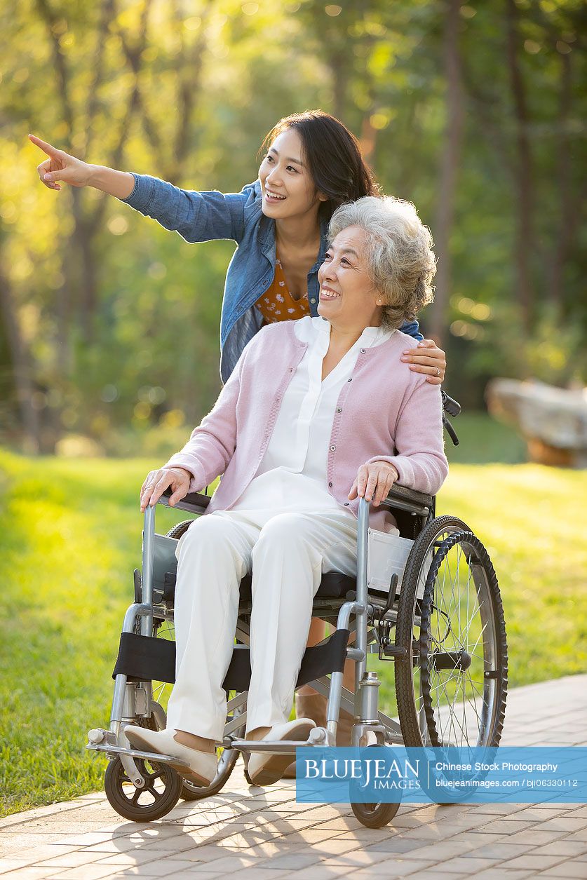 Happy Chinese mother and daughter relaxing in park