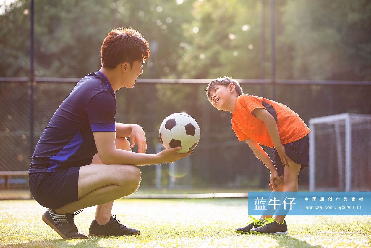 父子俩在足球场玩足球