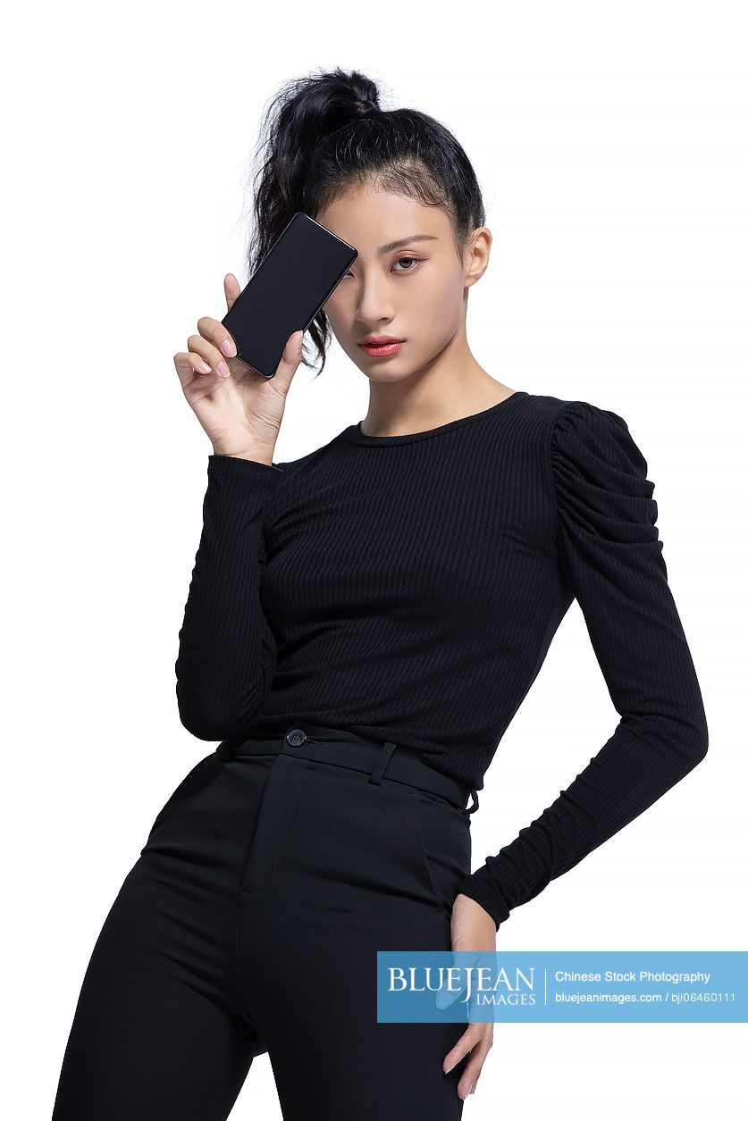 Fashionable young Chinese woman holding a smart phone