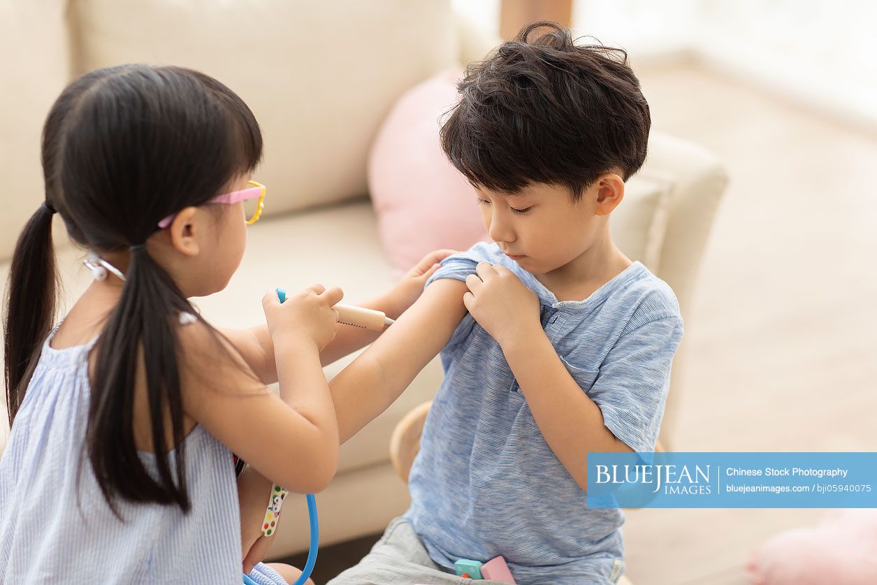 Cute Chinese girl playing doctor in living room
