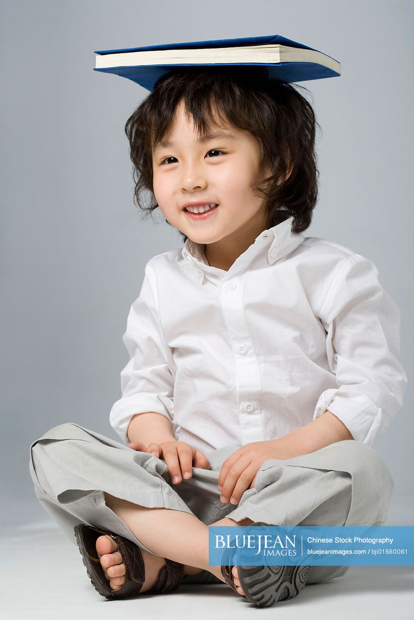 Chinese boy balancing a book on his head-High-res stock photo for download