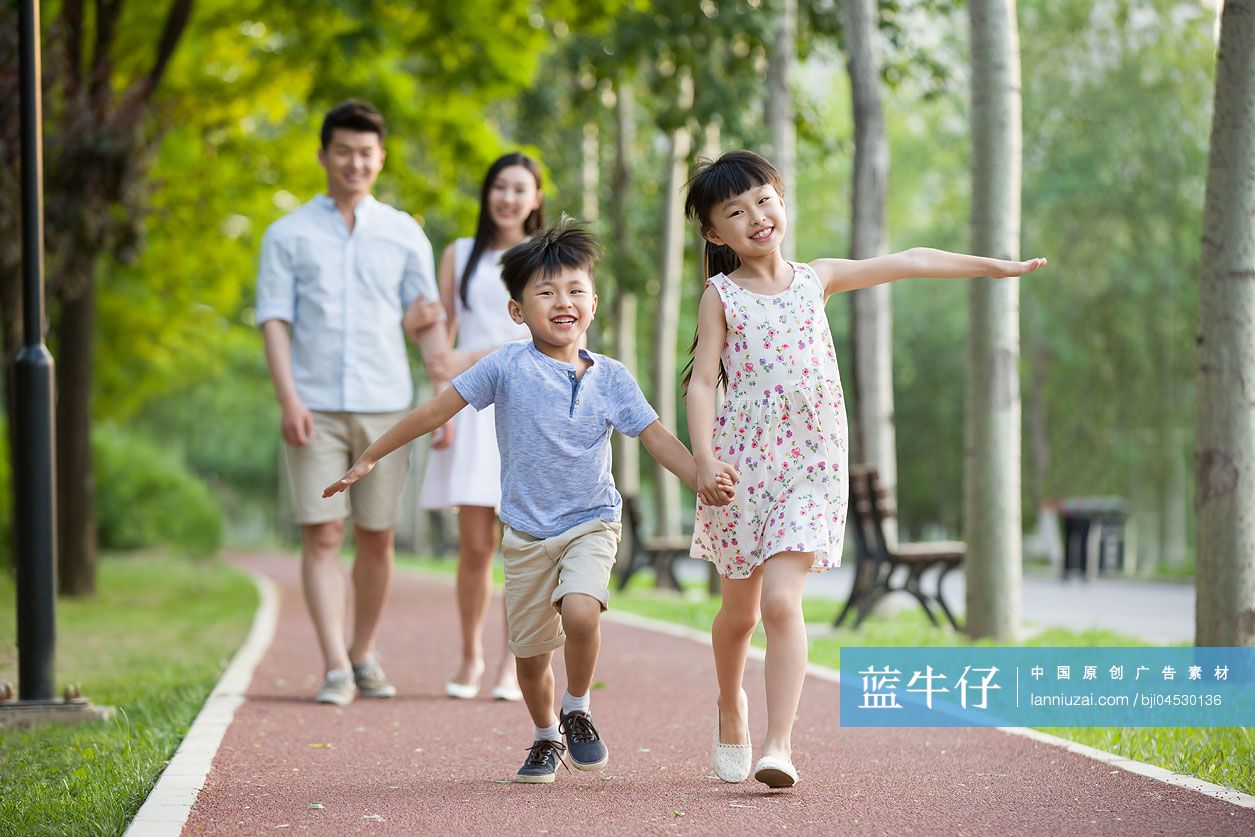 快乐的年轻家庭在公园嬉戏