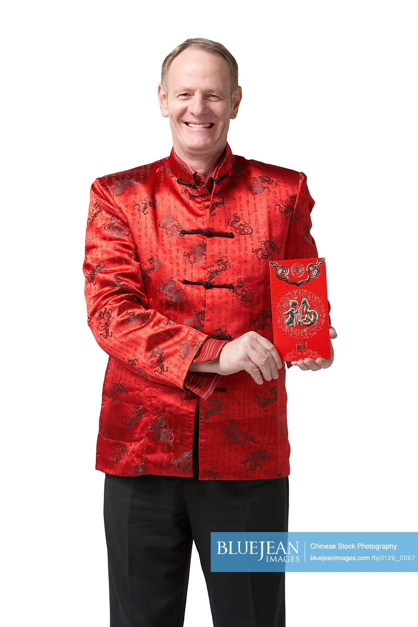 A man dressed for Chinese New Year holds a red envelope